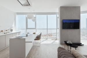 uma cozinha e sala de estar com armários brancos e um sofá em Sea and Sky Apartment em Odessa