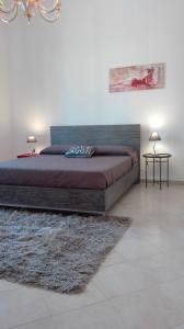 パレルモにあるAppartamento Delle Pergoleのベッドルーム1室(ベッド1台、ランプ2つ、ラグ付)