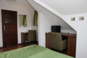 A television and/or entertainment centre at Rezydencja Nad Wigrami Standard & Comfort Rooms