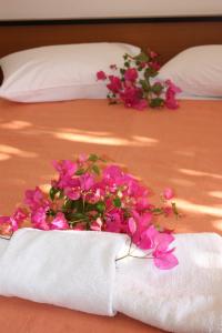 a bouquet of pink flowers sitting on a bed at Aktio Studios in Gavrion