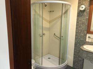 una doccia in vetro in un bagno con lavandino di Hotel Savoy Inn a Quito