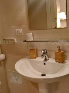 y baño con lavabo blanco y espejo. en Venticello Apartment, en Bari