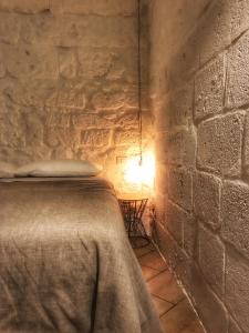 a bedroom with a bed in a stone wall at Cecenove in Capurso