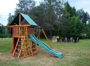 un parque infantil con tobogán y una casa de juegos en Dwight Village Motel en Dwight