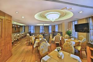 Un restaurante con mesas y sillas y un televisor de pantalla plana. en Adelmar Hotel Istanbul Sisli, en Estambul
