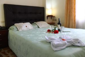 a bed with two towels and a bottle of wine at Hotel Andino Real in Bogotá