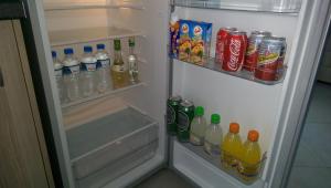 an open refrigerator filled with drinks and soda at Aimilias Family Apartments in Nea Vrasna