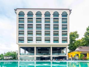 a large building with a large pool in front of it at Chiangkhong Teak Garden Riverfront Onsen Hotel- SHA Extra Plus in Chiang Khong