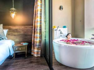 清孔Chiangkhong Teak Garden Riverfront Onsen Hotel- SHA Extra Plus的一间设有浴缸的房间,里面有一个孩子