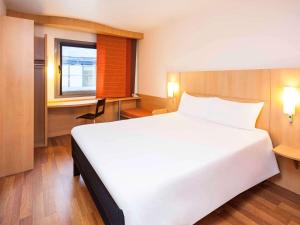 a hotel room with a bed and a desk at Ibis Madrid Alcobendas in Alcobendas