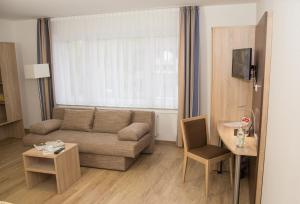 a living room with a couch and a table at Hotel Restaurant Lütkebohmert in Reken
