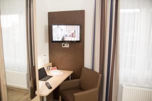a room with a desk with a laptop and a chair at Hotel Restaurant Lütkebohmert in Reken
