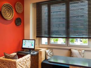 een kamer met een bureau, een computer en een raam bij ibis Styles Paris Boulogne Marcel Sembat in Boulogne-Billancourt