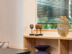 a shelf with three sculptures on it next to a window at ibis Styles Paris Boulogne Marcel Sembat in Boulogne-Billancourt