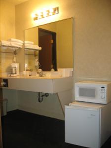 een badkamer met een wastafel en een magnetron bij Great Lakes Inn Mackinaw City in Mackinaw City