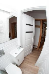 ソポトにあるBeach Apartment Monteの白いバスルーム(シンク、鏡付)