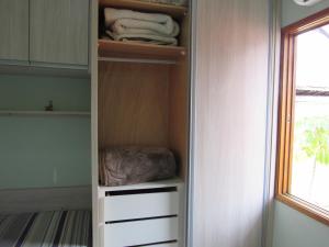 a closet with white shelves and a window at Hospedagem Granville in São Paulo
