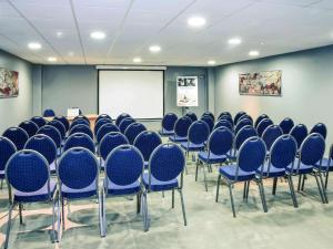 a conference room with blue chairs and a whiteboard at Mercure Périgueux Centre Historique in Périgueux
