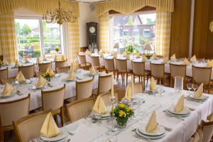 a set of tables and chairs in a room at Hotel Restaurant Lütkebohmert in Reken