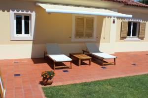 two chairs and a table on a patio at Dunas Golf House in Cascais