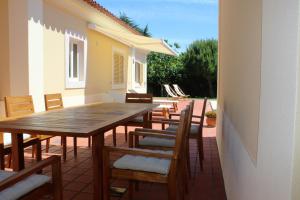 a wooden table and chairs on a patio at Dunas Golf House in Cascais
