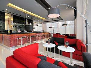 a living room filled with furniture and a red couch at Ibis Bangkok Sukhumvit 4 - SHA Extra Plus in Bangkok
