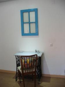 una mesa con una silla y una ventana azul en Casa dos Pedro´s en Vila Nova