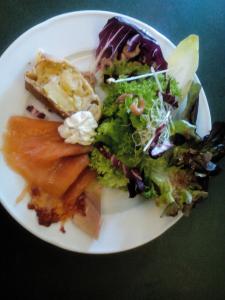 a white plate with a salad and food on it at Hotel Restaurant Lütkebohmert in Reken