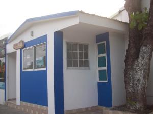 ein kleines Haus mit einer blauen Tür und einem Baum in der Unterkunft Alojamientos Turisticos Titanic in San Andrés