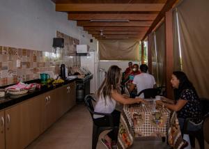 a group of people sitting at a table in a kitchen at Pousada Araxá in Araxá