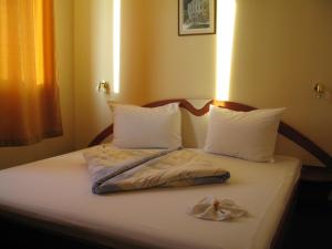 Una cama con dos almohadas y un arco. en Family Hotel Familya, en Ruse