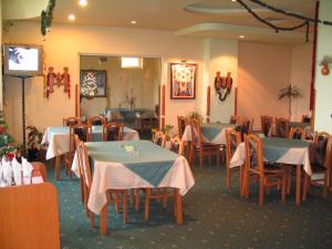Family Hotel Familya في روس: غرفة طعام بها طاولات وكراسي وتلفزيون