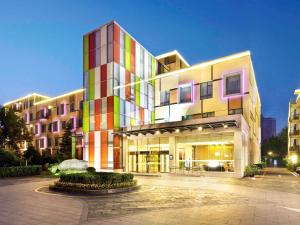 a large building with a colorful facade at Mercure Beijing Downtown in Beijing