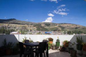a table and chairs on a balcony with a mountain at La Casa de Justi in Huancayo