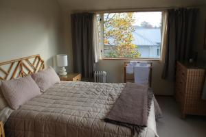 Un dormitorio con una cama grande y una ventana en Aroha Riccarton Bed and Breakfast, en Christchurch