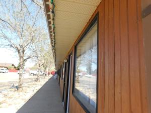 Un edificio con ventanas de vidrio en los costados. en Cedar Villa Motel, en Foremost