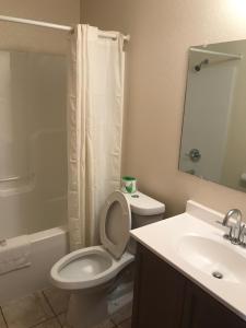 a bathroom with a toilet and a sink and a shower at Western Holiday Motel in Wichita