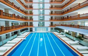 a large indoor pool with chairs and a swimming poolomedasteryasteryasteryasteryastery at MekongView 2 CondoTel in Phnom Penh