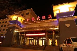 un edificio con escritura china por la noche en Dunhuang Gold Dragon Hotel, en Dunhuang