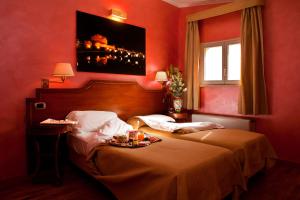a hotel room with two beds with a tray of food on the bed at Hotel Kent in Rome