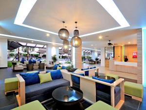 a lobby with a blue couch and chairs in a building at Ibis Phuket Kata in Kata Beach