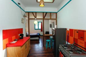 cocina con fogones y encimera roja en Casa Violeta Limón, en Valparaíso