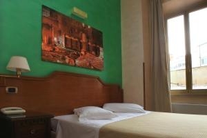 a bedroom with a green wall and a bed at Hotel Kent in Rome
