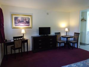 a hotel room with a television and two tables and chairs at Travelers Motel in Cottonwood