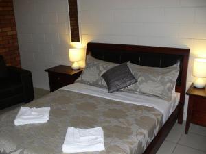 um quarto com uma cama com toalhas em Susan River Homestead em Hervey Bay