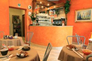 two tables and chairs in a restaurant with orange walls at Hotel Kent in Rome
