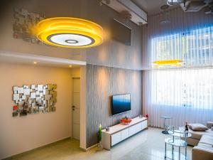 a living room with a couch and a television at FaRoyal Luxury Suite in Eilat