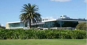 ein Gebäude mit einer Palme davor in der Unterkunft Palm Garden Villa-Apt - Tropical Oasis at Cronulla Beach in Cronulla