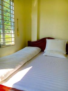 two twin beds in a room with a window at Huyen Tram Guesthouse in Dồng Văn +13 photos