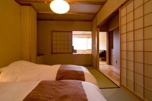 a bedroom with a bed and a window in it at Miyama Ouan Kyoritsu Resort in Takayama